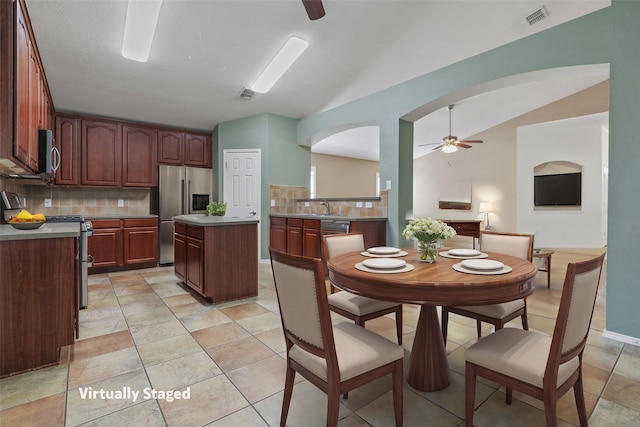 11279 Snyder Dr, Frisco, TX 75035 - kitchen featuring stainless steel appliances, a ceiling fan, vaulted ceiling, backsplash, and arched walkways