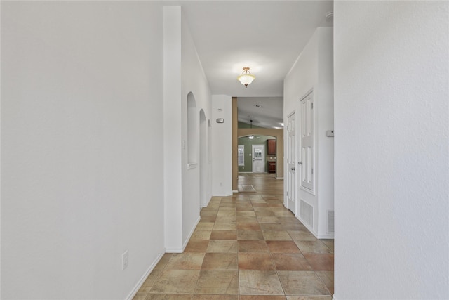 11279 Snyder Dr, Frisco, TX 75035 - hallway with arched walkways, baseboards, and light stone finish flooring