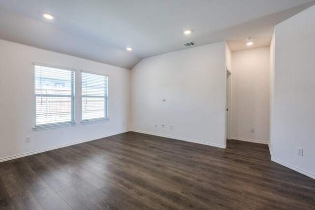 spare room with visible vents, baseboards, lofted ceiling, recessed lighting, and dark wood-style flooring
