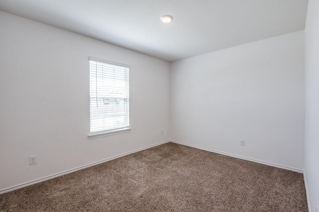 carpeted empty room with baseboards