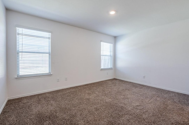 carpeted spare room featuring baseboards