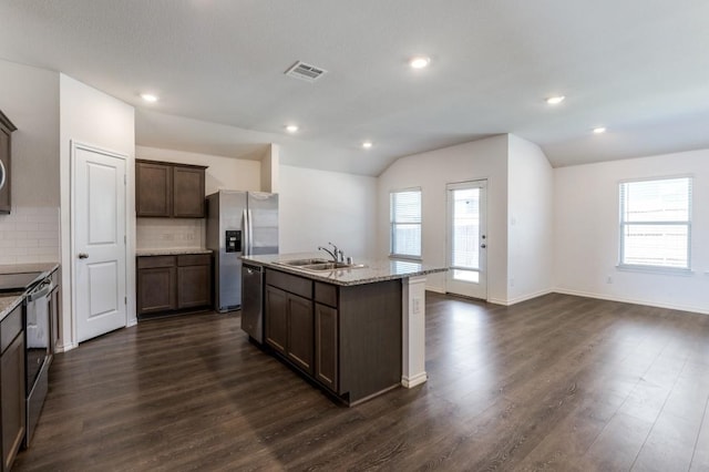 kitchen featuring visible vents, a sink, dark wood-style floors, appliances with stainless steel finishes, and vaulted ceiling
