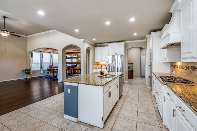 9848 Robinwoods Dr, Frisco, TX 75035 - kitchen with arched walkways, a sink, appliances with stainless steel finishes, ornamental molding, and a ceiling fan