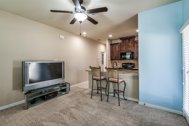 9848 Robinwoods Dr, Frisco, TX 75035 - kitchen with black appliances, a kitchen breakfast bar, light carpet, a ceiling fan, and dark brown cabinets