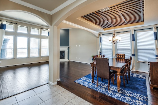 9848 Robinwoods Dr, Frisco, TX 75035 - tiled dining room featuring a chandelier, healthy amount of natural light, arched walkways, baseboards, and ornamental molding