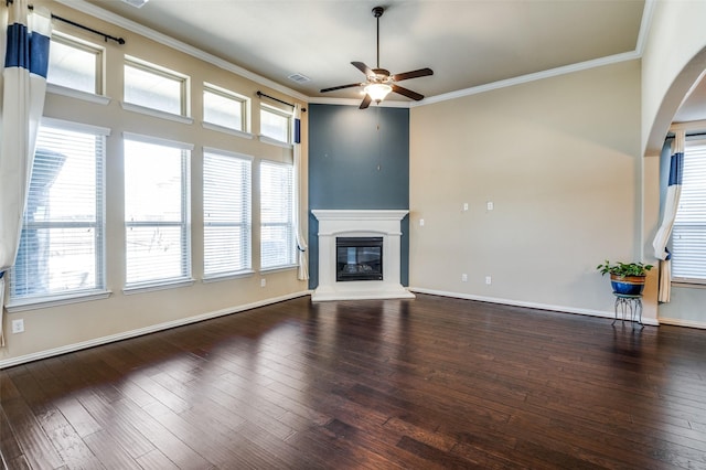 9848 Robinwoods Dr, Frisco, TX 75035 - unfurnished living room featuring ceiling fan, wood-type flooring, crown molding, a glass covered fireplace, and arched walkways