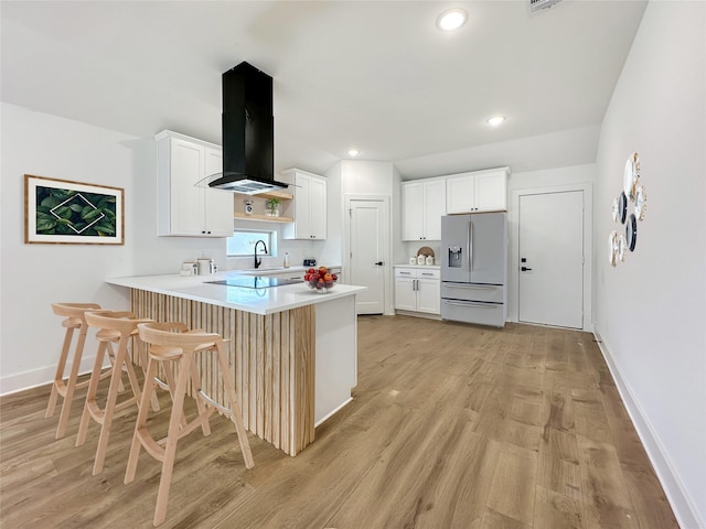 kitchen with refrigerator with ice dispenser, white cabinetry, a peninsula, exhaust hood, and light countertops