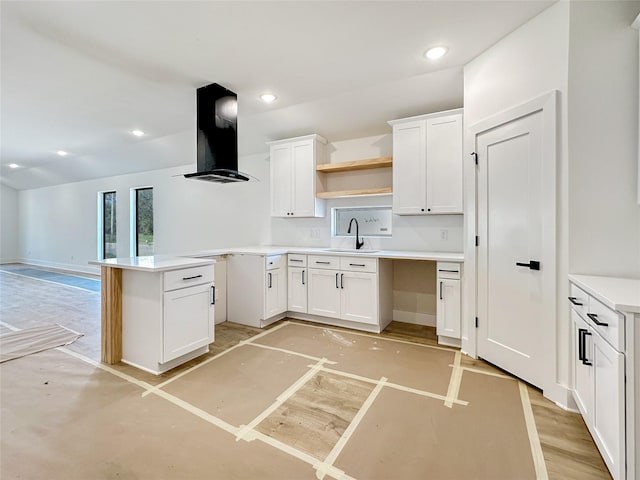 kitchen featuring island exhaust hood, open shelves, a sink, white cabinetry, and recessed lighting