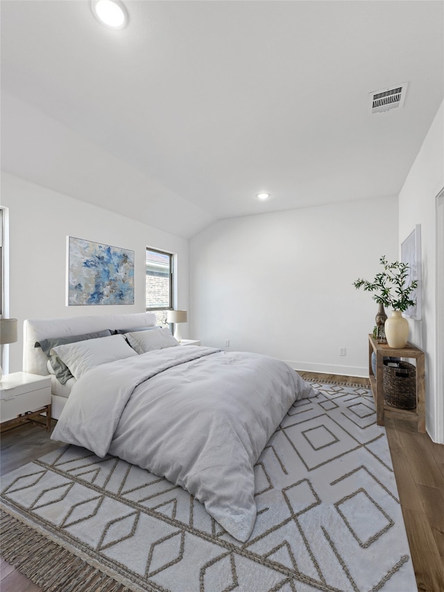 bedroom with visible vents, recessed lighting, lofted ceiling, and wood finished floors