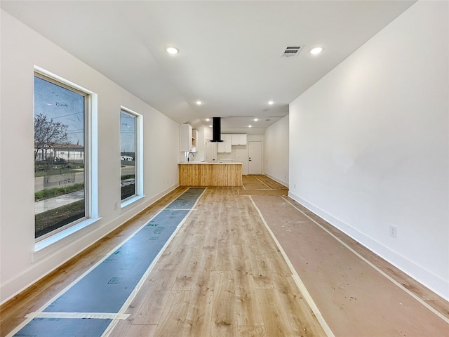 unfurnished living room with recessed lighting, visible vents, baseboards, and light wood finished floors