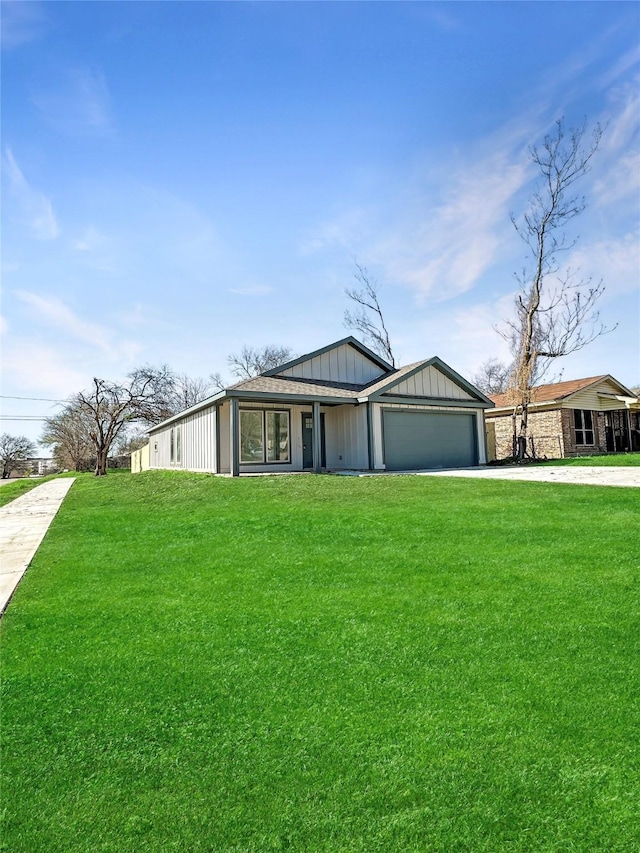 mid-century inspired home featuring a front yard, concrete driveway, and a garage