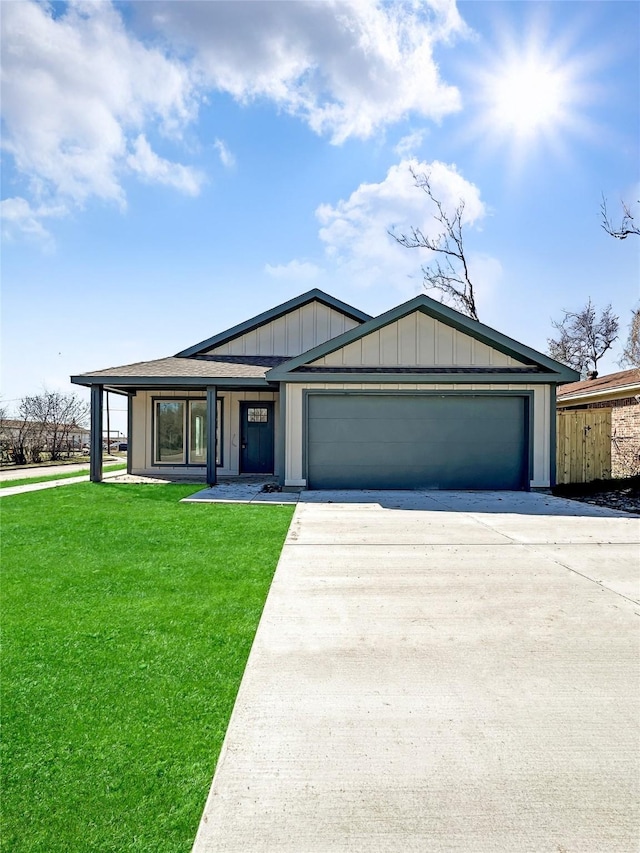 view of front of house with a garage, driveway, board and batten siding, and a front lawn