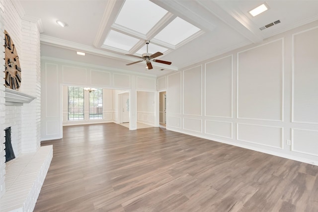 unfurnished living room featuring visible vents, light wood-style flooring, a decorative wall, and a fireplace
