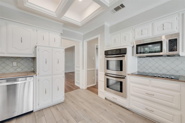 kitchen featuring crown molding, appliances with stainless steel finishes, light wood-style flooring, visible vents, and coffered ceiling