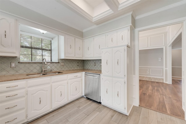 kitchen with crown molding, white cabinetry, a sink, and dishwasher