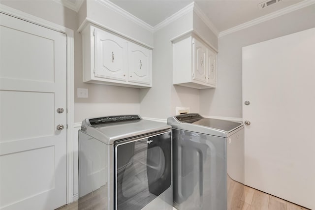 clothes washing area with crown molding, visible vents, light wood-style floors, cabinet space, and independent washer and dryer
