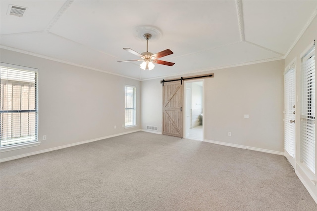 unfurnished bedroom featuring light colored carpet, a barn door, and multiple windows