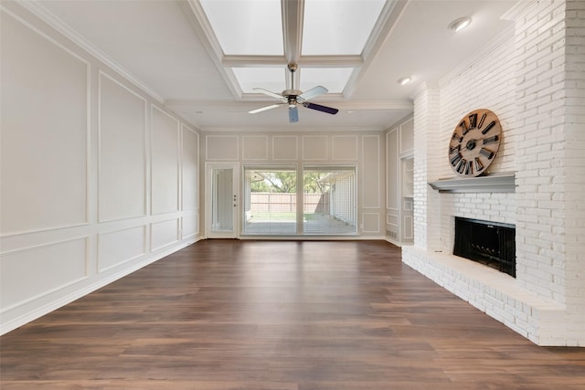 unfurnished living room featuring a fireplace, a decorative wall, dark wood finished floors, a ceiling fan, and ornamental molding
