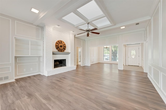 unfurnished living room with visible vents, built in features, a brick fireplace, beam ceiling, and a decorative wall
