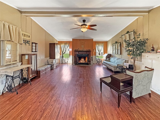 living area featuring vaulted ceiling, ceiling fan, and ornamental molding