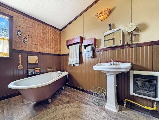 full bath with crown molding, lofted ceiling, wood finished floors, and wainscoting