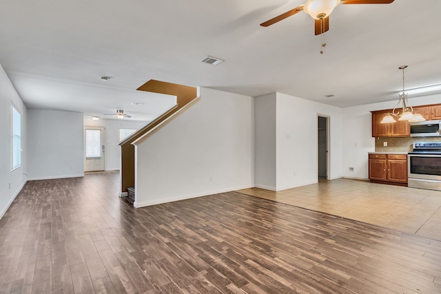 8529 Star Thistle Dr, Fort Worth, TX 76179 - unfurnished living room with visible vents, stairs, a ceiling fan, and wood finished floors