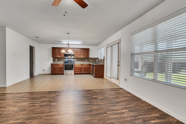 8529 Star Thistle Dr, Fort Worth, TX 76179 - kitchen featuring backsplash, wood finished floors, appliances with stainless steel finishes, light countertops, and ceiling fan