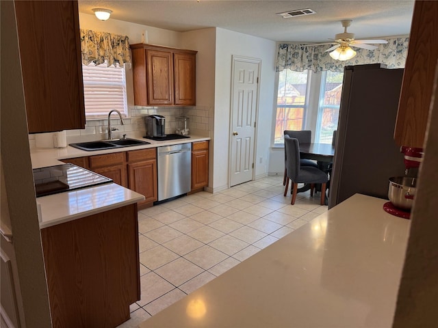 kitchen featuring light tile patterned floors, visible vents, a sink, light countertops, and stainless steel dishwasher