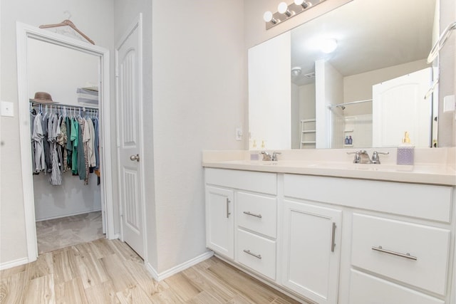 2015 Brenham Dr, Forney, TX 75126 - full bath with double vanity, a walk in closet, a shower, wood finished floors, and baseboards