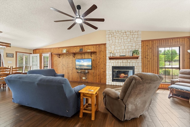 251 Dunn Dr, Palo Pinto, TX 76484 - living room featuring vaulted ceiling, ceiling fan, wood walls, dark wood finished floors, and a fireplace