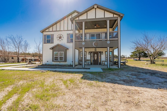 rear view of property with a patio area, board and batten siding, and a ceiling fan