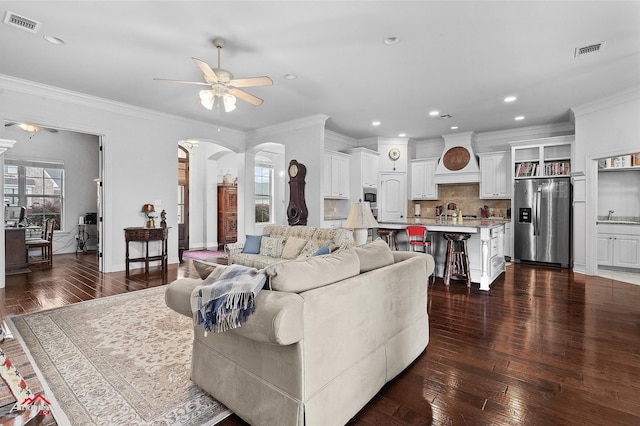3032 Sagefield Ln, Haughton, LA 71037 - living room featuring a ceiling fan, arched walkways, dark wood finished floors, ornamental molding, and recessed lighting
