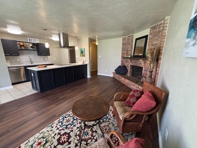 128 W Way Dr, Allen, TX 75002 - living area featuring visible vents, baseboards, light wood-style floors, a textured ceiling, and a brick fireplace
