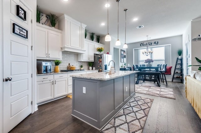 kitchen with visible vents, stainless steel refrigerator with ice dispenser, white cabinets, and dark wood-style floors