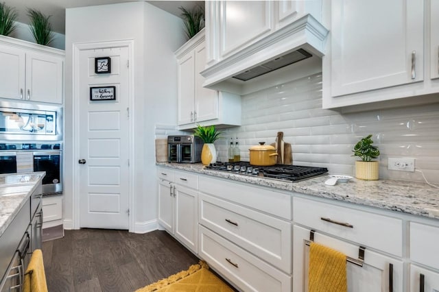 kitchen featuring white cabinetry, appliances with stainless steel finishes, custom range hood, and dark wood-type flooring
