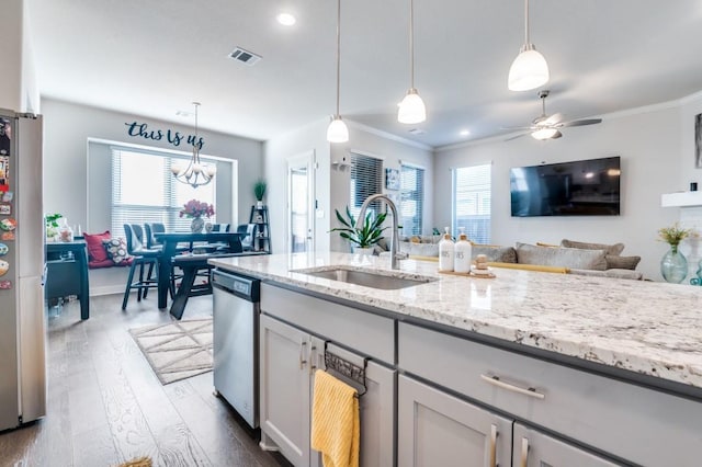 kitchen featuring visible vents, appliances with stainless steel finishes, light stone countertops, dark wood finished floors, and a sink