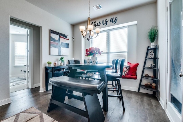 dining area featuring visible vents, baseboards, dark wood-style floors, and an inviting chandelier