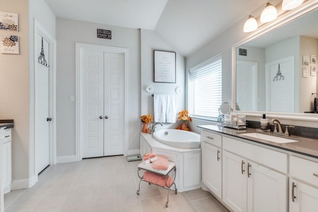 full bathroom with vanity, tile patterned floors, lofted ceiling, a garden tub, and a closet