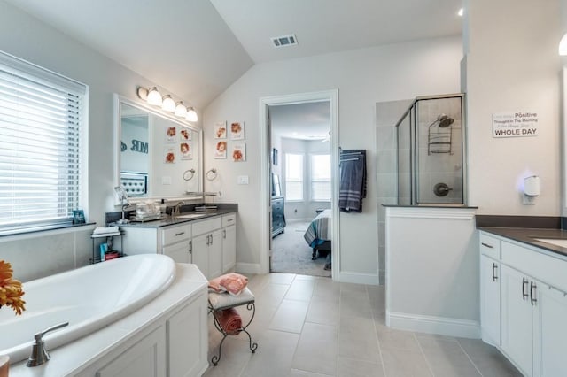 bathroom with vaulted ceiling, vanity, a shower stall, and visible vents