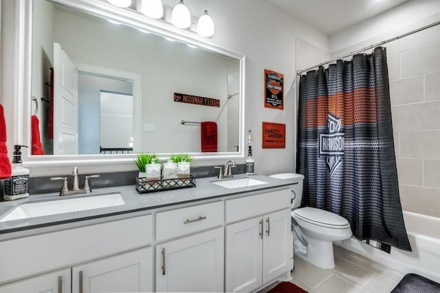 bathroom with double vanity, toilet, a sink, and tile patterned flooring