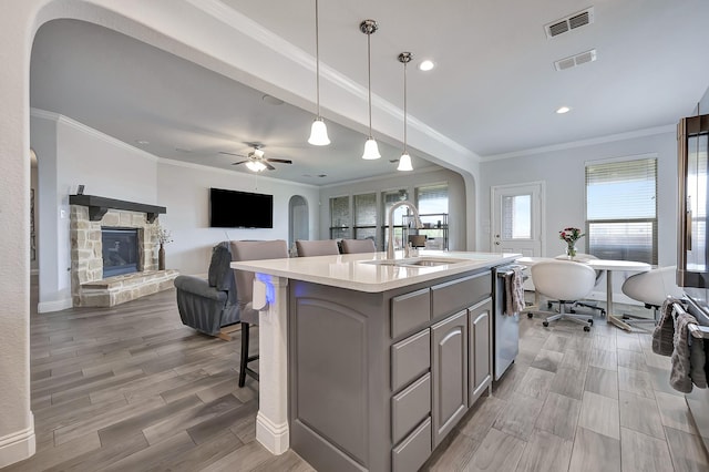 304 Welch Folly Ln, Aledo, TX 76008 - kitchen with a sink, gray cabinetry, light countertops, a fireplace, and a breakfast bar