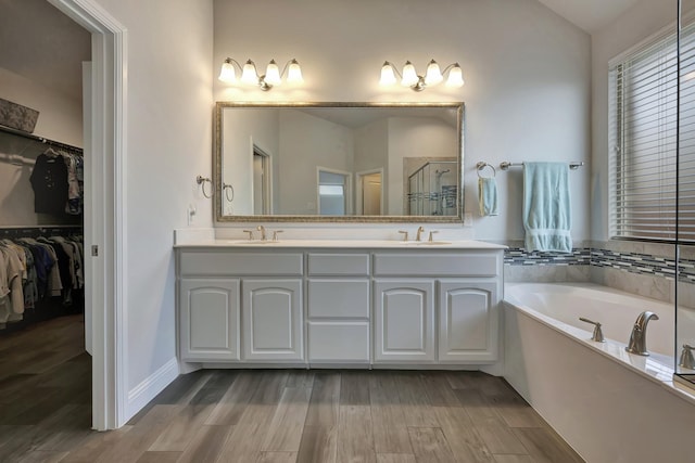 304 Welch Folly Ln, Aledo, TX 76008 - full bath featuring wood finished floors, double vanity, a bath, a walk in closet, and a stall shower