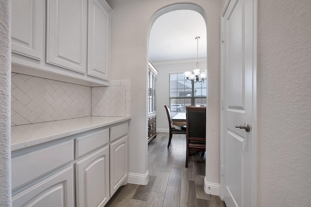 304 Welch Folly Ln, Aledo, TX 76008 - hallway with a chandelier, crown molding, baseboards, arched walkways, and dark wood-style floors