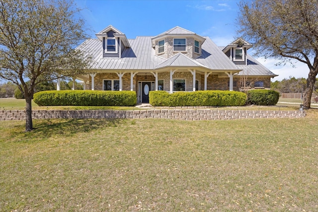 view of front of property featuring a porch, metal roof, and a front yard