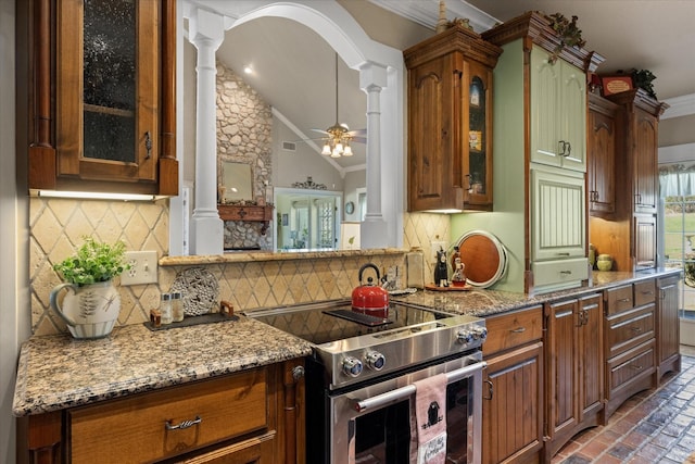 kitchen with brick floor, decorative columns, crown molding, stainless steel range with electric stovetop, and tasteful backsplash