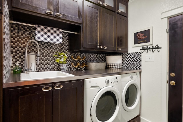 laundry area featuring cabinet space, independent washer and dryer, and a sink