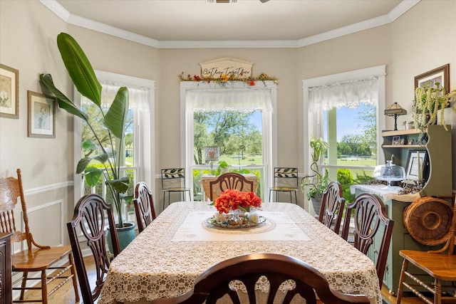 dining room with crown molding, plenty of natural light, and wood finished floors