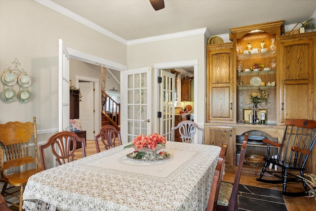 dining room with a ceiling fan, french doors, crown molding, and dark wood-style floors