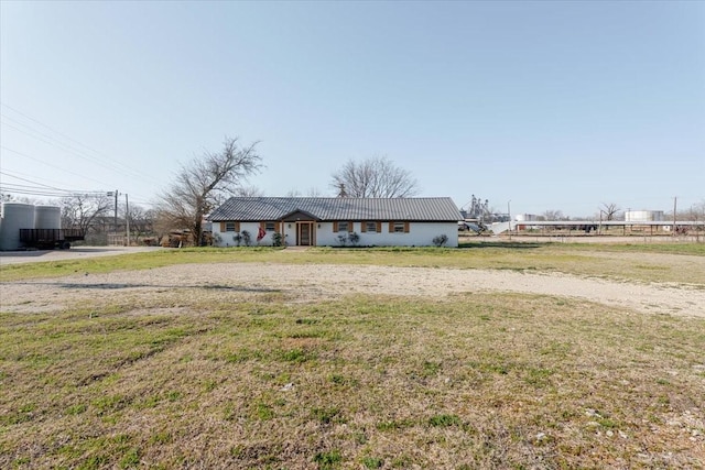 ranch-style house featuring metal roof and a front lawn
