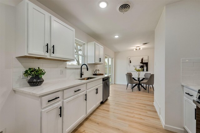 2809 Maple Dr, Garland, TX 75042 - kitchen with a sink, stainless steel dishwasher, tasteful backsplash, white cabinets, and recessed lighting